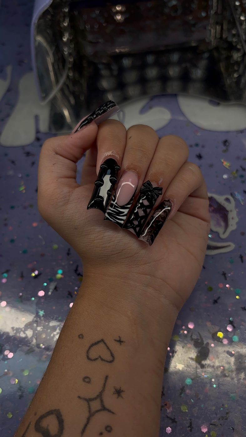 Lia nail art with long black alternative nails, white line art, and dark graphic accents.