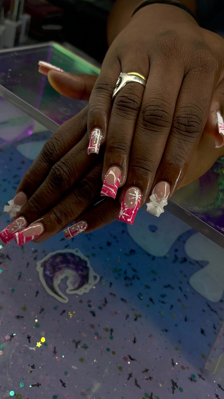 Lia nail art with red, pink, and white mixed designs, gems, and decorative accents.