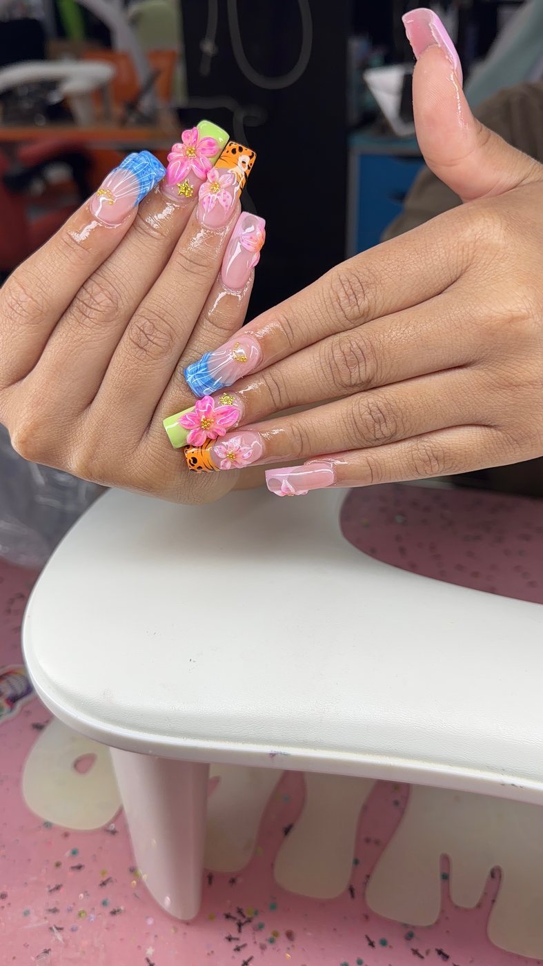 Serenity nail art with pink flowers, blue accents, and gold details.