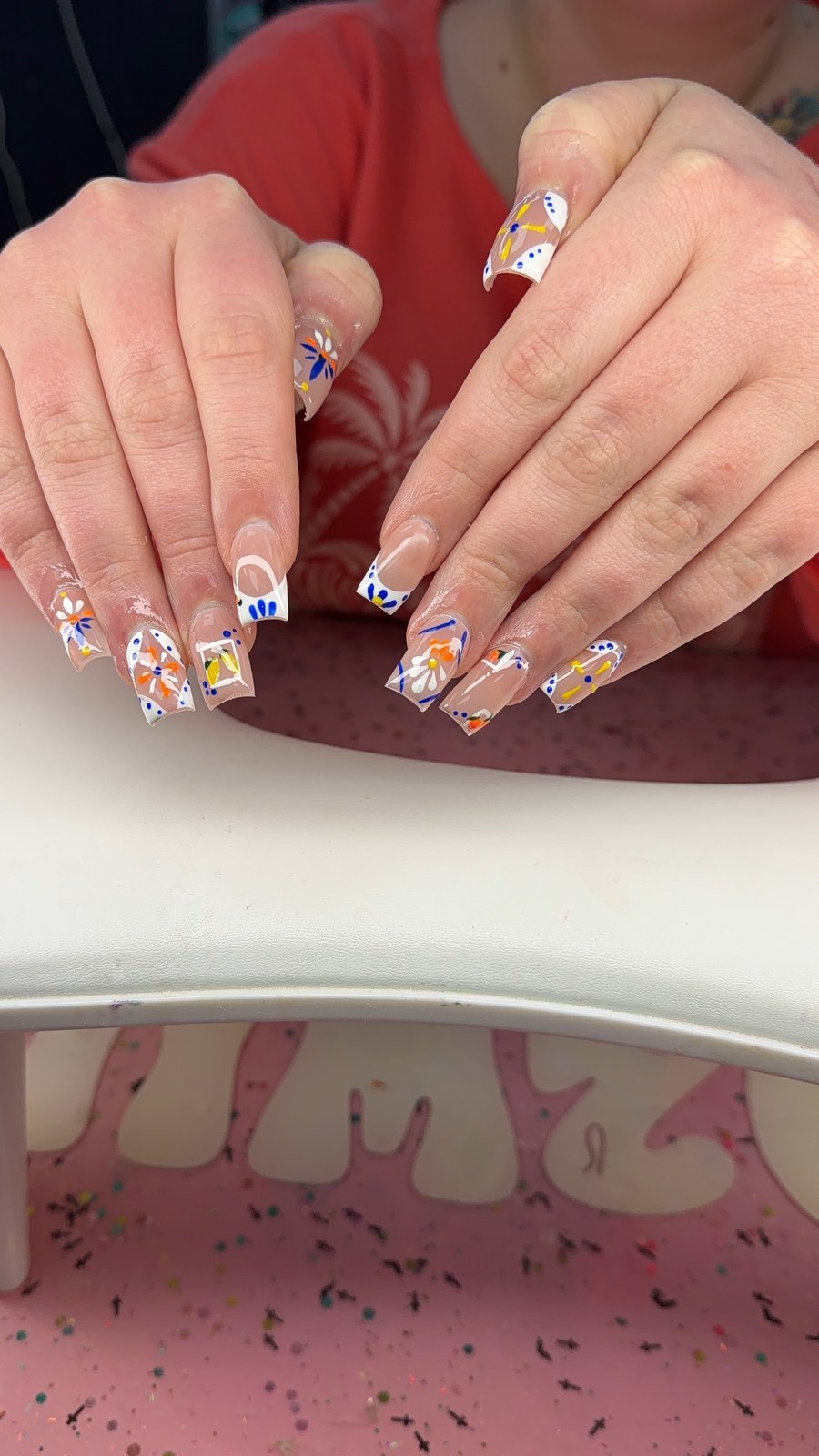 Serenity nail art with white French tips, blue dots, and colorful painted flowers.